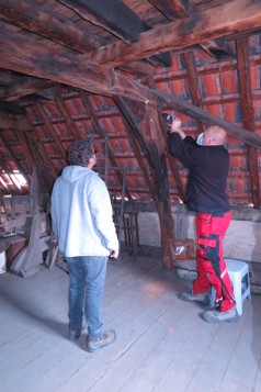 Denkmalpfleger bohrt das Gebälk eines Dachstuhls an