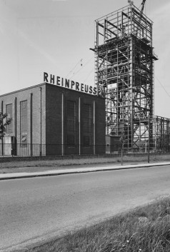 Backsteingebäude mit Schriftzug "Rheinpreussen" und eingerüstetem Förderturm